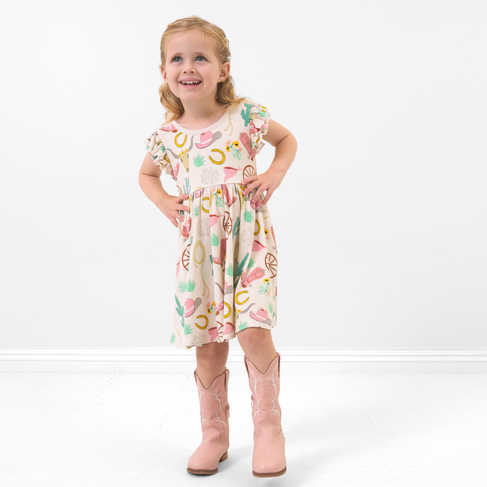 Child posing wearing a Pink Ready to Rodeo twirl dress