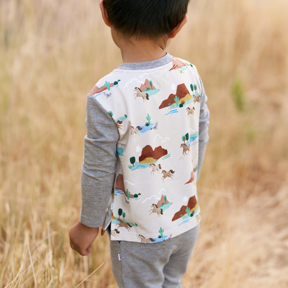 Boy wearing the Trail Blazers Henley Tee and displaying the back detail while also wearing the Heather Gray Jogger