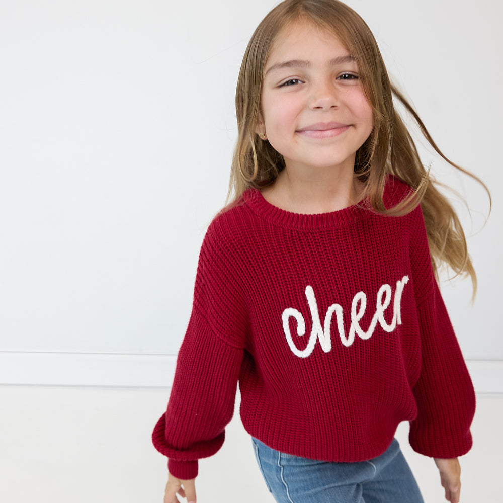 Alternate close up image of a child wearing a Deep Crimson "Cheer" Drop Shoulder Crewneck