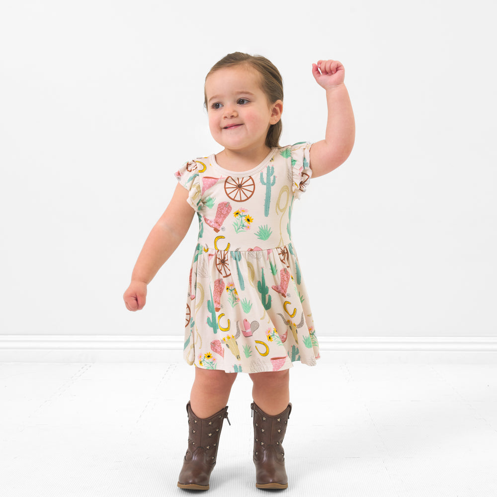 Child dancing wearing a Pink Ready to Rodeo twirl dress with bodysuit