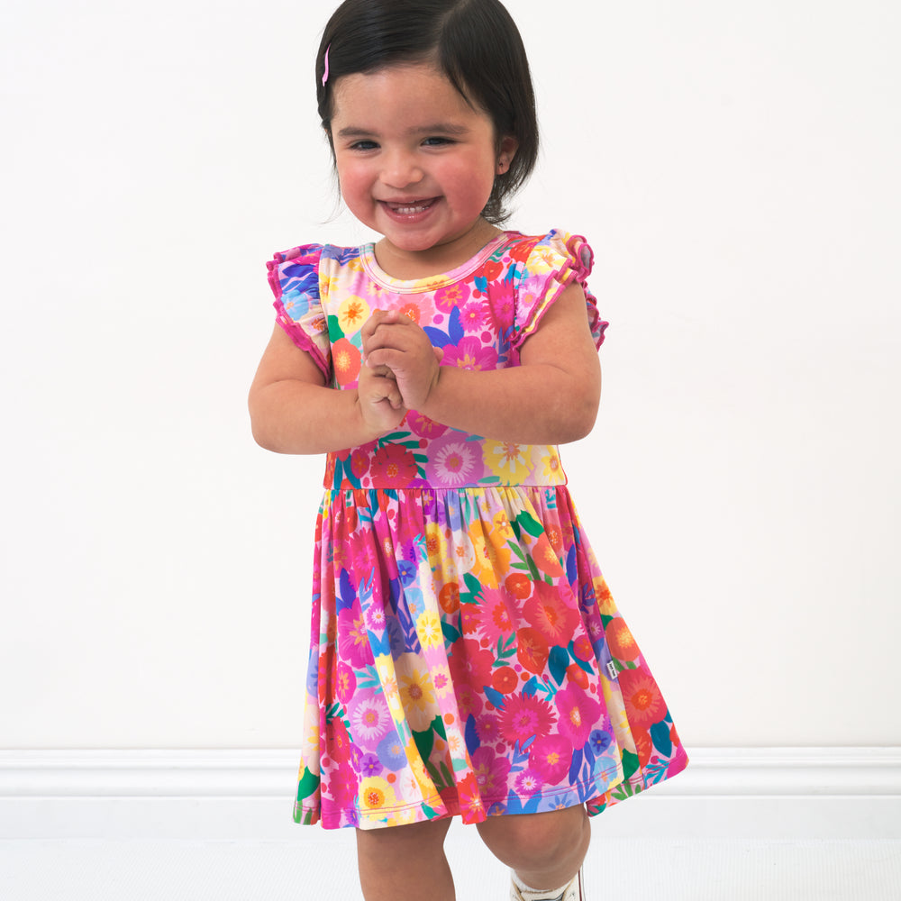 Child wearing a Rainbow Blooms flutter twirl dress with bodysuit