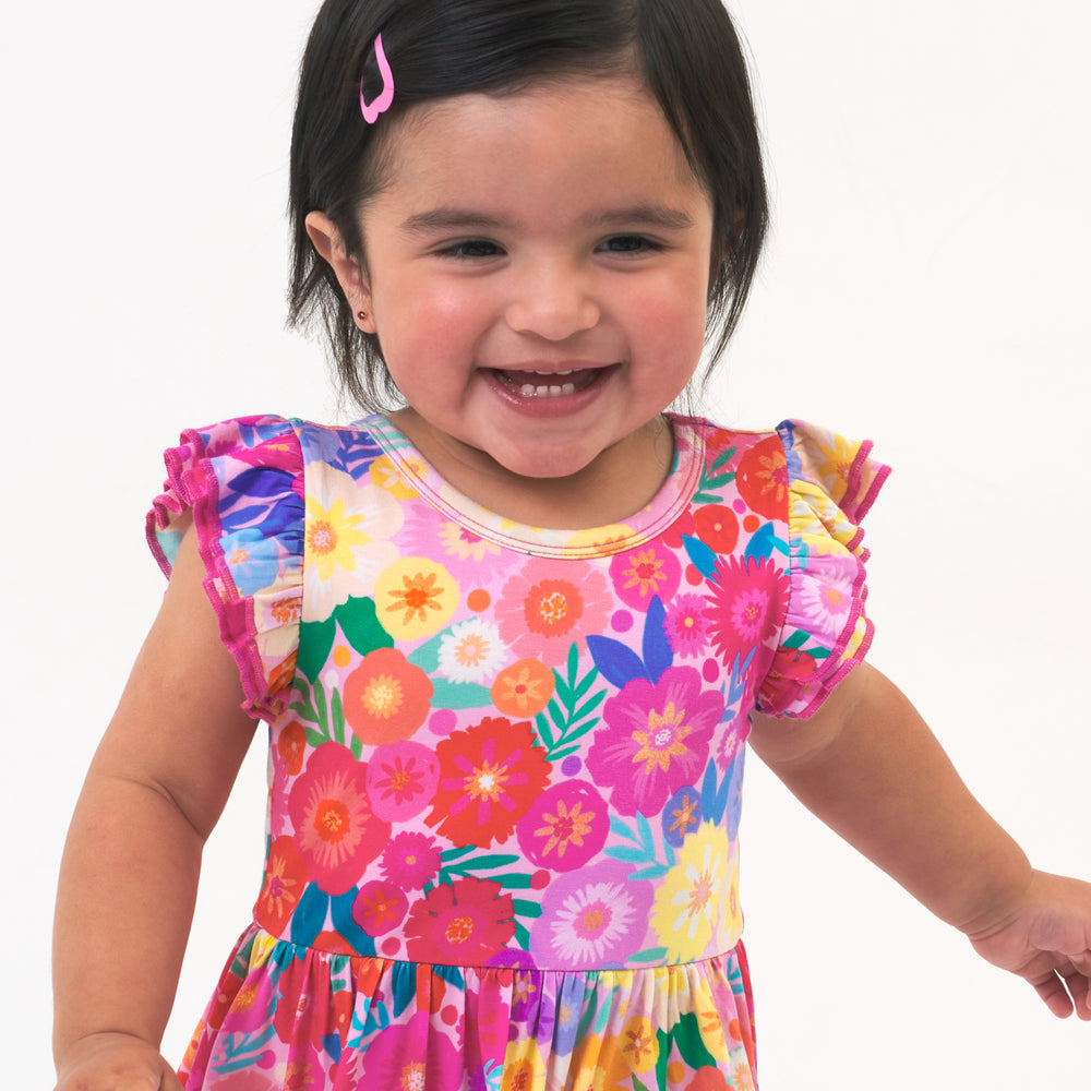 Close up image of a Rainbow Blooms flutter twirl dress with bodysuit