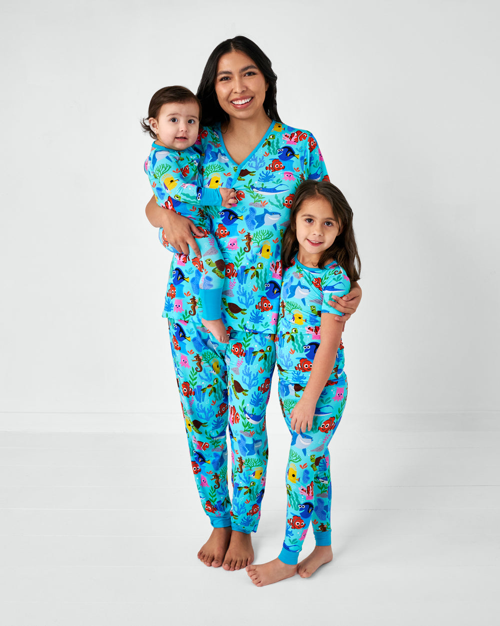 Mother and two children wearing matching Nemo's Reef pajamas