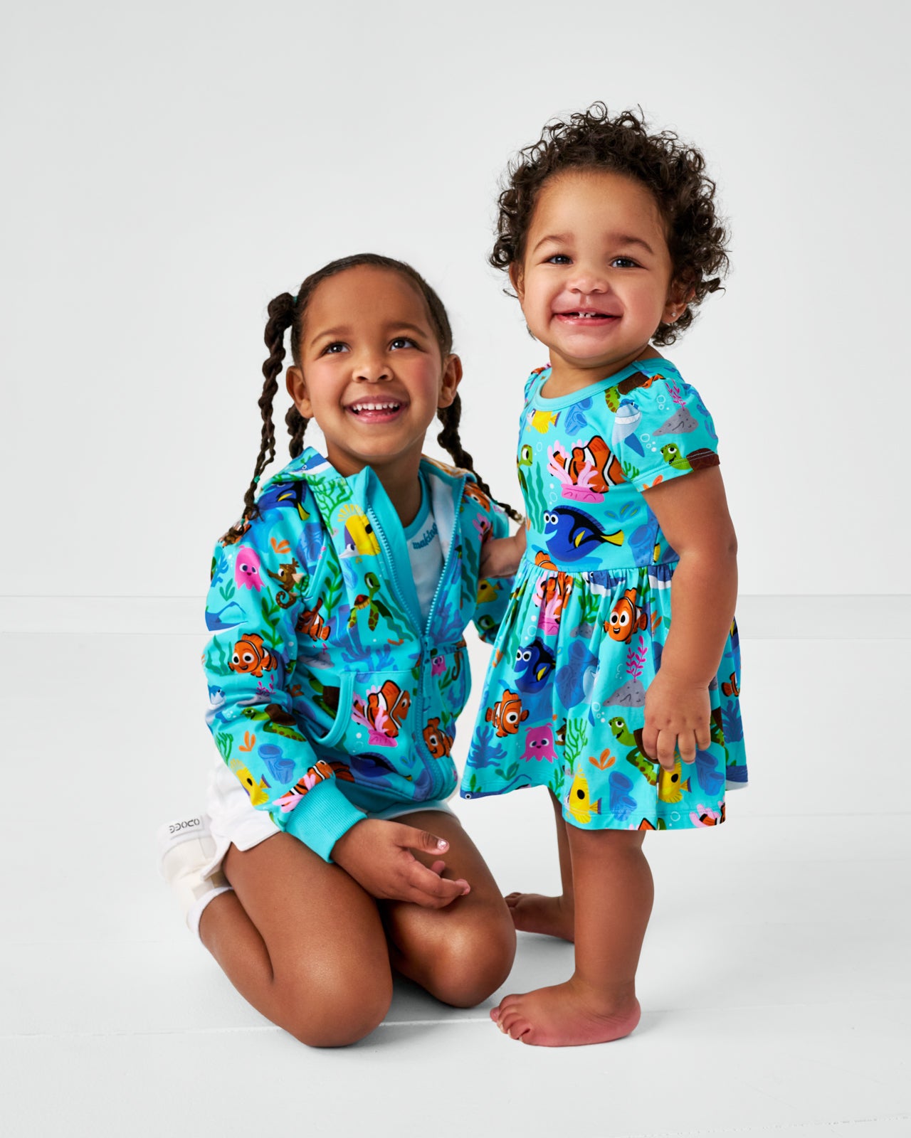 Two girls wearing matching Pixar Nemo's Reef play styles