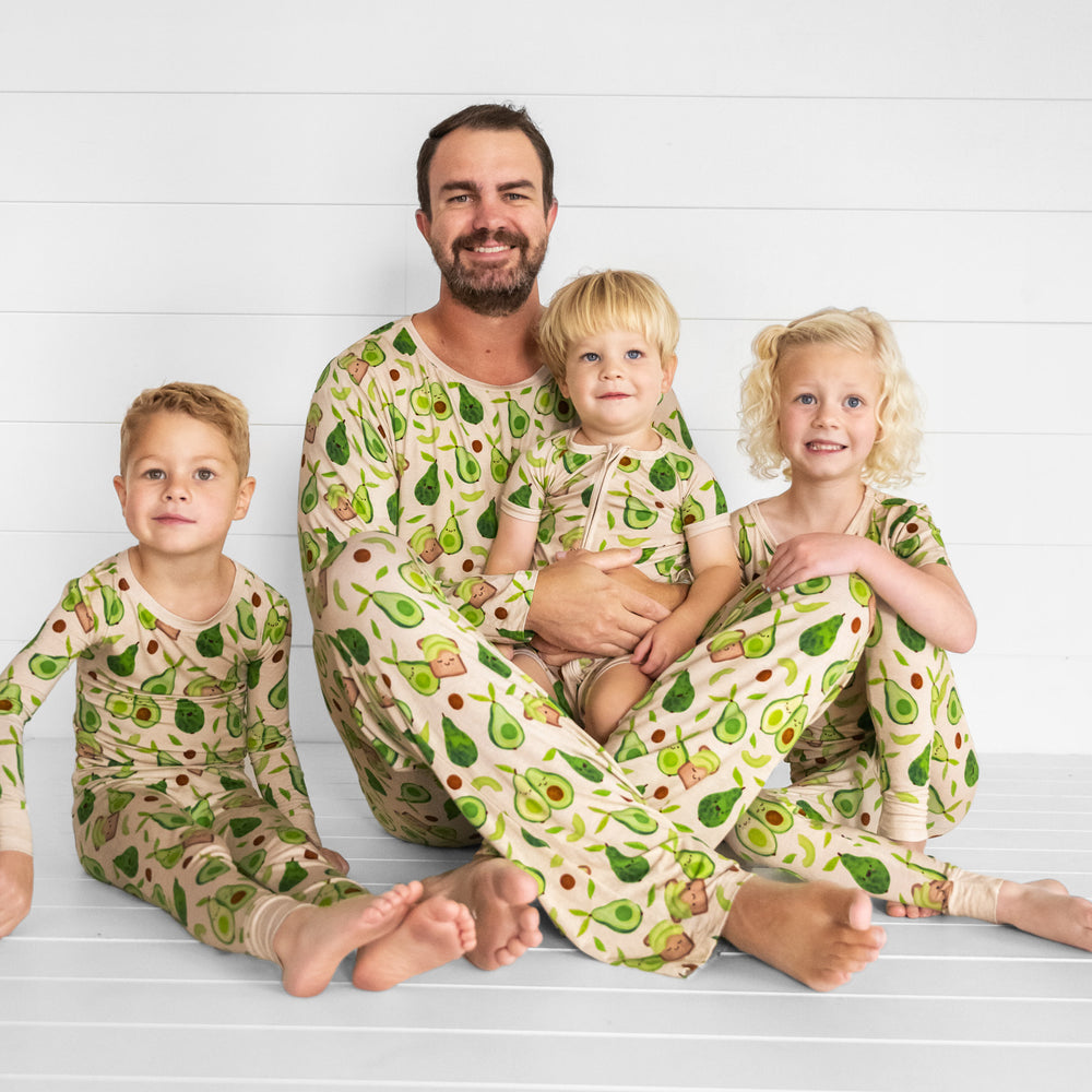 father and his three children wearing matching Avocado Toast pjs in men's top and pants styles, and children's zippy and two piece styles.