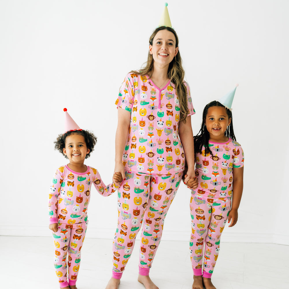 Mother and her two children wearing matching Pink Party Pals pjs. Mom is wearing women's Pink Party Pals women's pj top and matching women's pj pants. Children are wearing matching pj sets