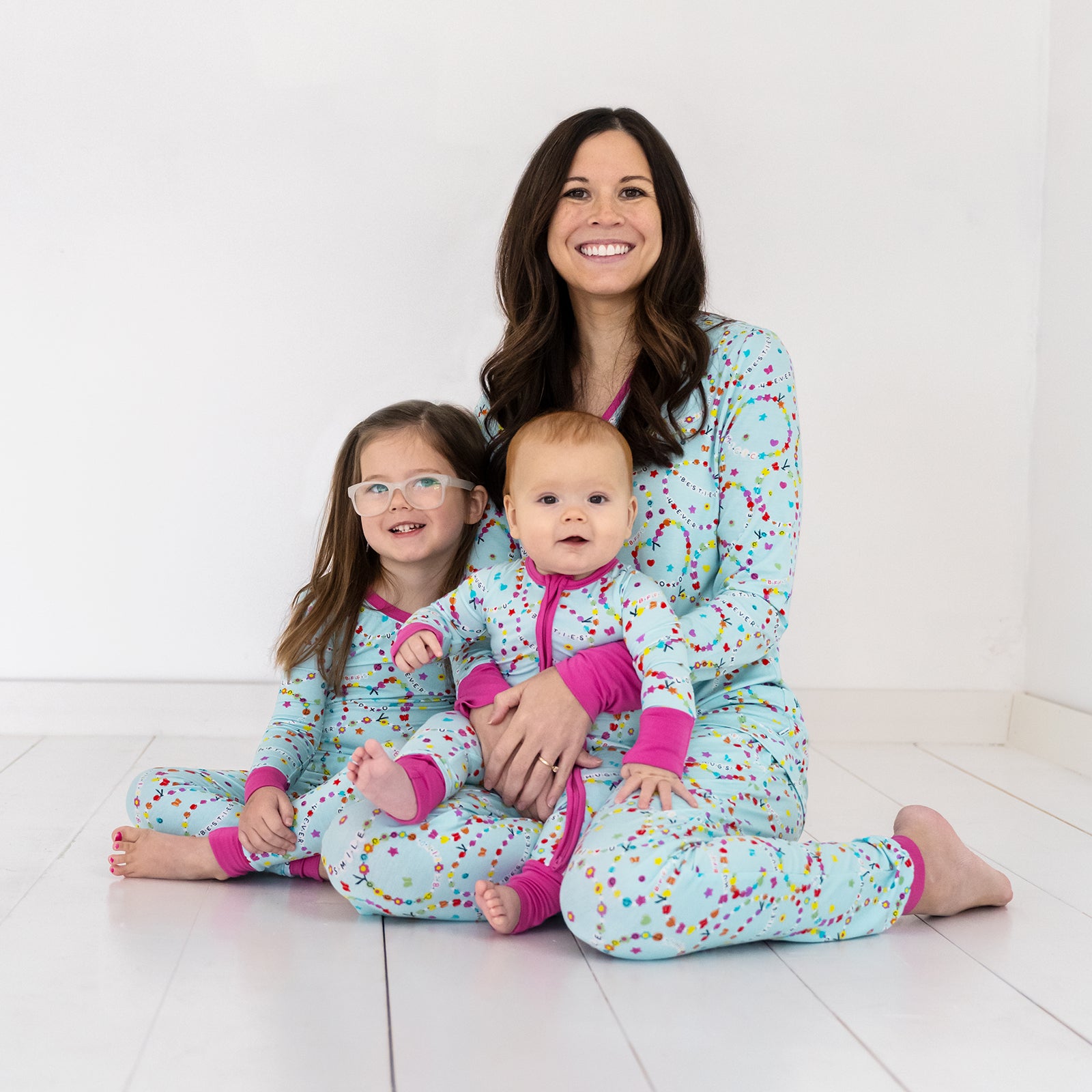 Mother and her two children wearing matching Friends Forever pjs. Dressed in women's pj top and bottoms, and children's zippy and two piece styles.