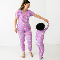 Mother and daughter dancing together wearing matching Magical Birthday pjs. Mom is wearing women's Magical Birthday pj top and matching pj pants. Child is wearing magical birthday two piece pj set