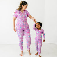 Mother and daughter dancing together wearing matching Magical Birthday pjs. Mom is wearing women's Magical Birthday pj top and matching pj pants. Child is wearing magical birthday two piece pj set