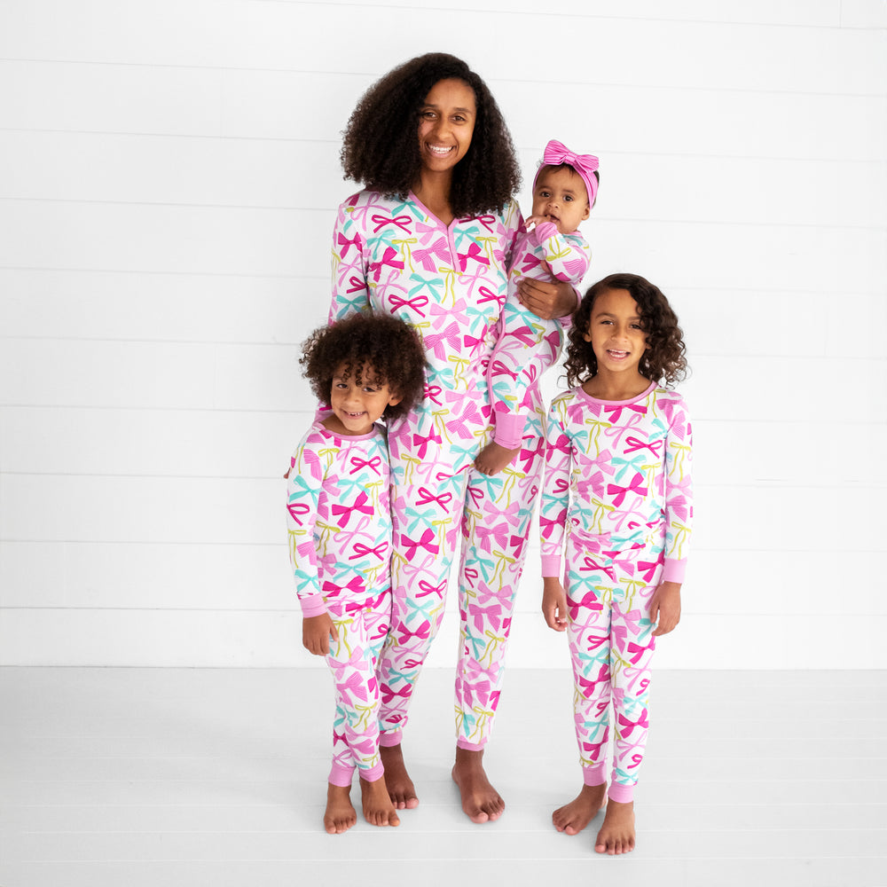 mom and her three children wearing matching Ribbons and Bows pj sets in women's and children's two piece and zippy styles. Her youngest is wearing a matching Pink Tonal Stripes luxe bow headband