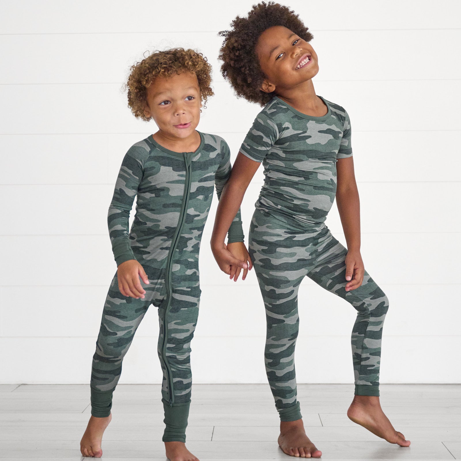 Boy on the left is in the Vintage Camo Zippy and boy on the right is wearing the Vintage Camo Two-Piece Short Sleeve Pajama Set