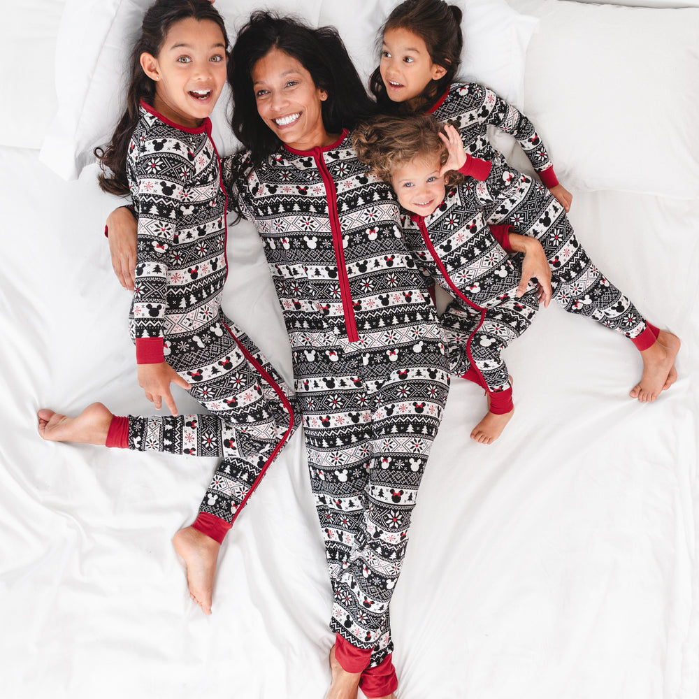 woman laying on a bed cuddling her two children wearing matching zippies in women's and children's styles