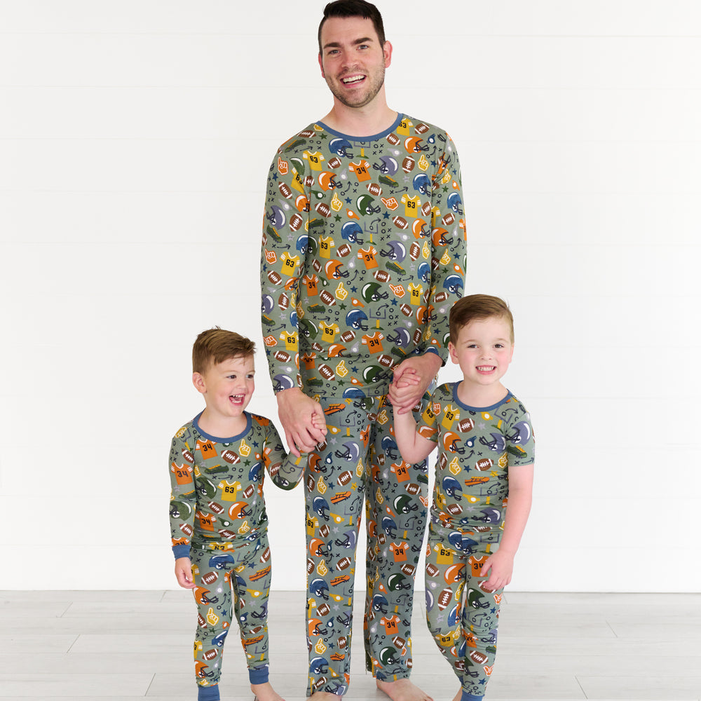 Boy on the left is wearing the touchdown-time-two-piece-pajama-set, the father in the middle is wearing the touchdown-time-mens-pajama- top & pants. The boy on the right is the touchdown-time-two-piece-short-sleeve-pajama-set