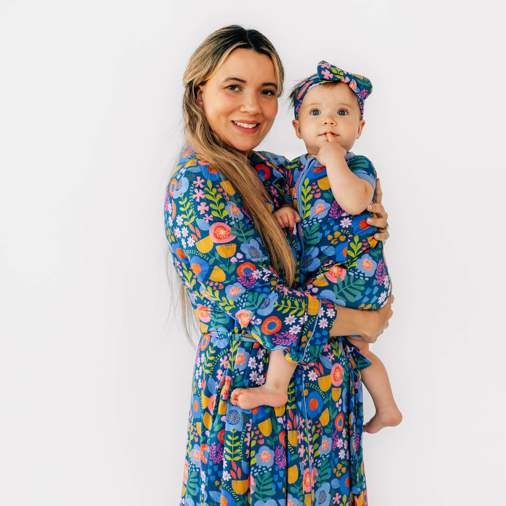 Mother and daughter wearing the Folk Floral print. Child is wearing the Folk Floral Luxe Bow Headband and the Shorty Zippy in Folk Floral and mother is wearing the Folk Floral Woman's Robe