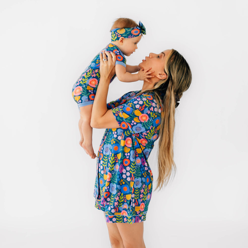 Mother and daughter wearing the Folk Floral print. Girl is wearing the Folk Floral Luxe Bow Headband and the Shorty Zippy in Folk Floral and Mother is wearing the Folk Floral Woman's Short-sleeve Shorts PJ Set