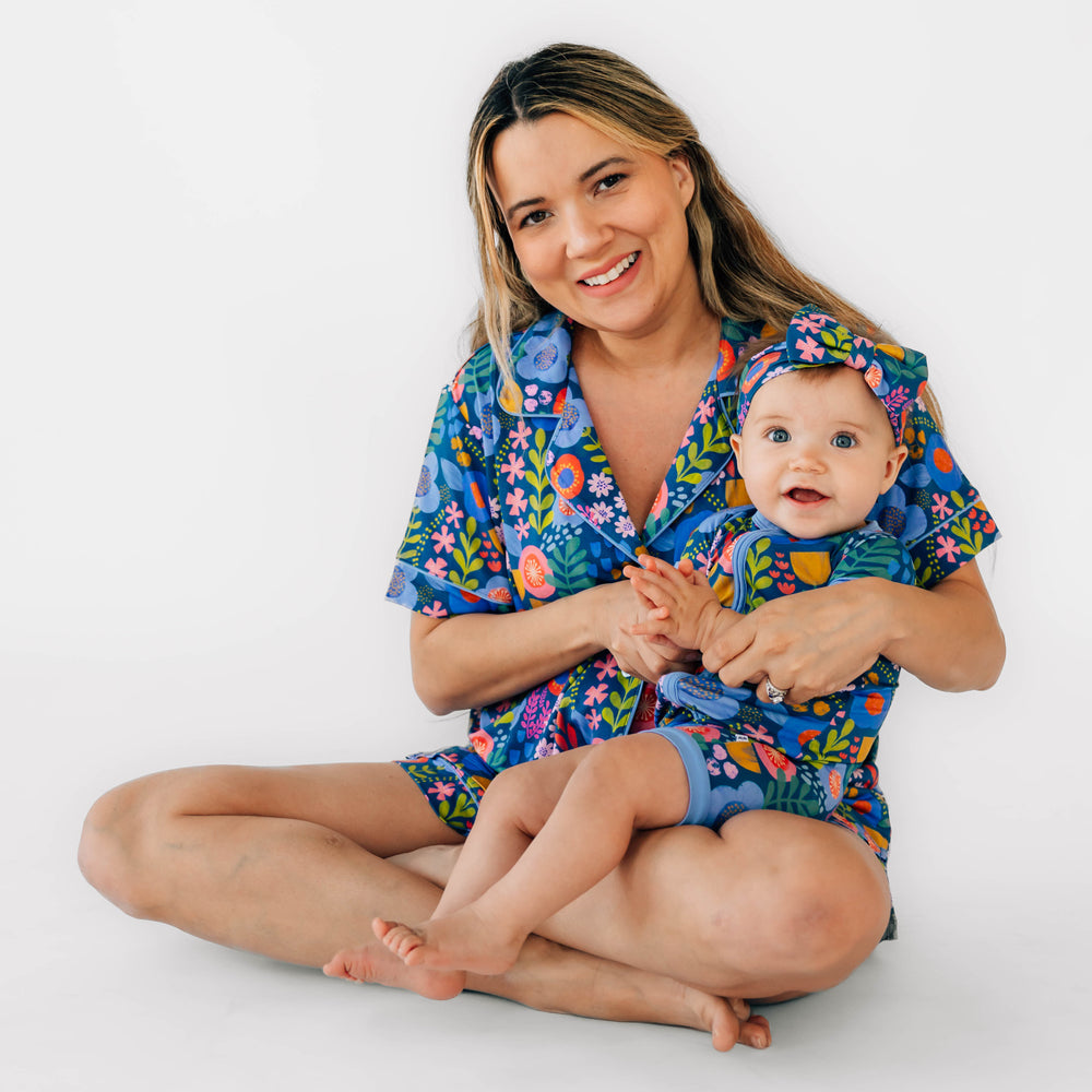 Mother and daughter wearing the Folk Floral print. Daughter is wearing the Folk Floral Luxe Bow Headband and the Folk Floral Shorty Zippy and mother is wearing the Folk Floral Woman's Short-sleeve Shorts PJ Set