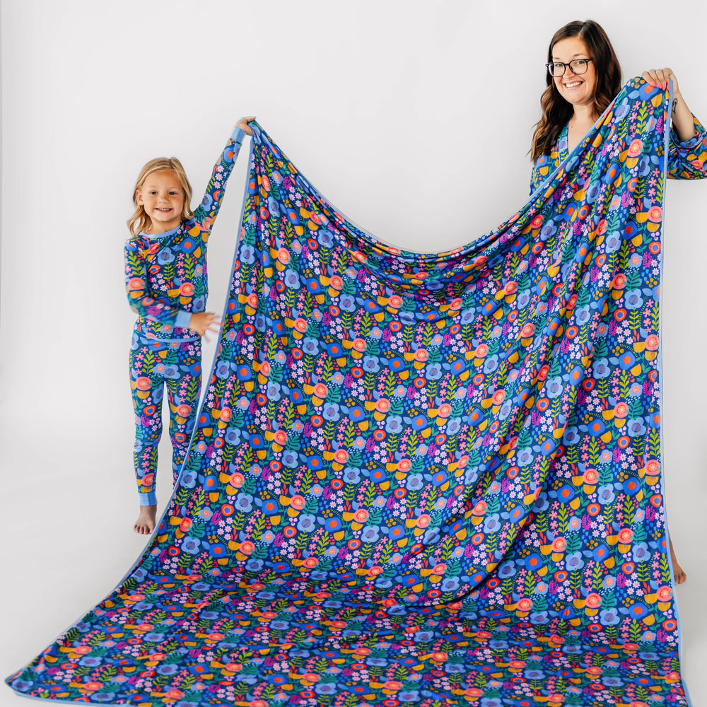 Mother and child standing with the Folk Floral Oversized Cloud Blanket®. Child is wearing the Long-sleeve Pajama Set in Folk Floral 