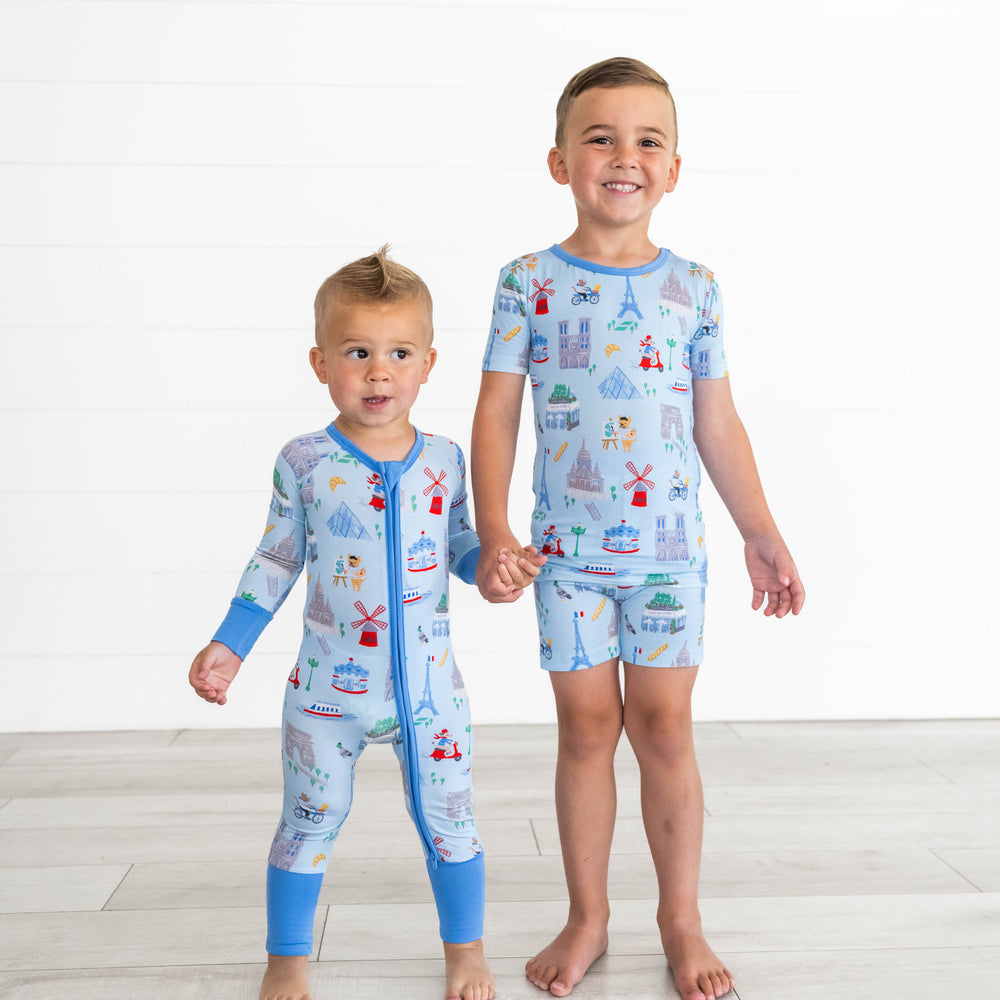 Boy on the left is wearing the Blue Weekend in Paris Zippy and boy on the left is in the Blue Weekend in Paris Two-Piece Short Sleeve & Shorts Pajama Set