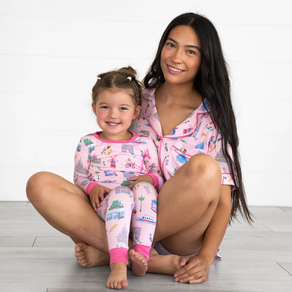 Mother and daughter wearing the Pink Weekend in Paris print. Girl is in the Pink Weekend in Paris Two-Piece Pajama Set and mother is wearing the Pink Weekend in Paris Short-sleeve Pajama Set