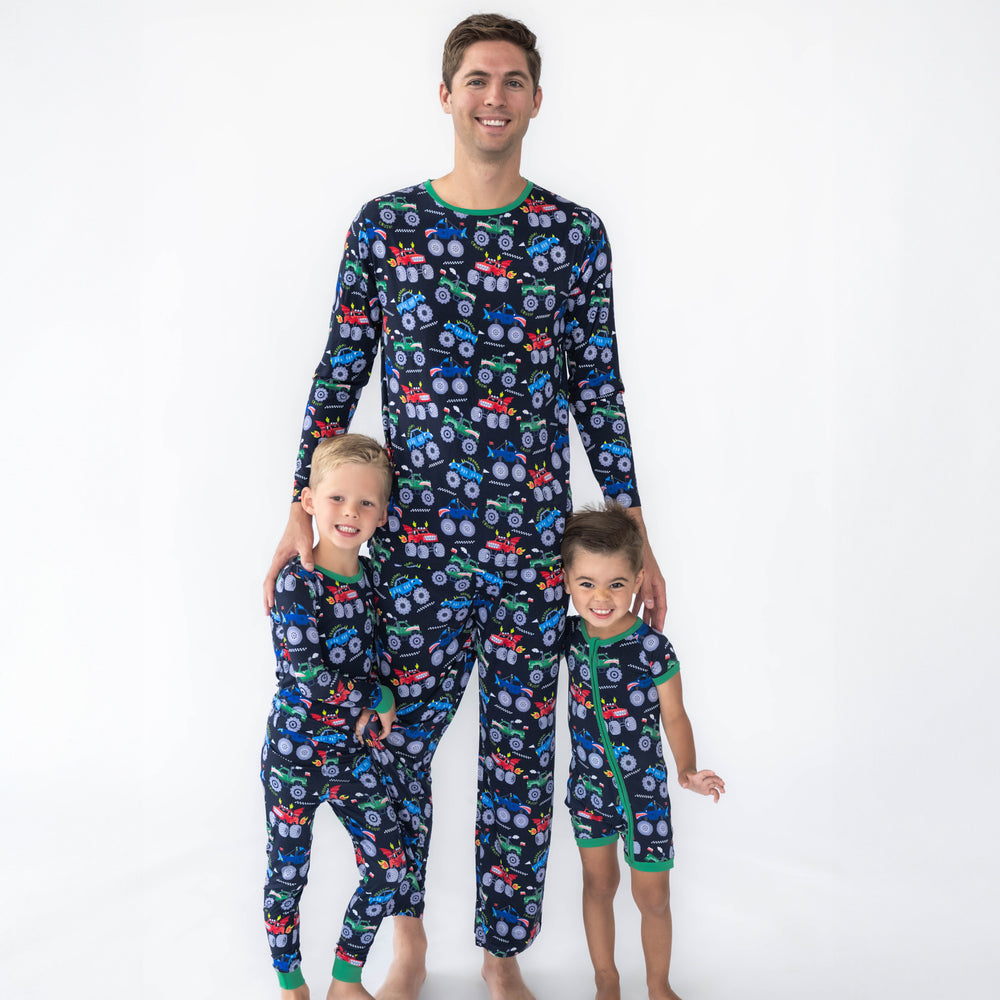 Father and sons wearing the Monster Truck Madness print. Boy on the left is wearing the Monster Truck Madness Pajama Set and father in the middle is wearing the Monster Truck Madness Men's Pajama Pants & Monster Truck Madness Men's Pajama Top. Boy on the right is wearing the Monster Truck Madness Shorty Zippy