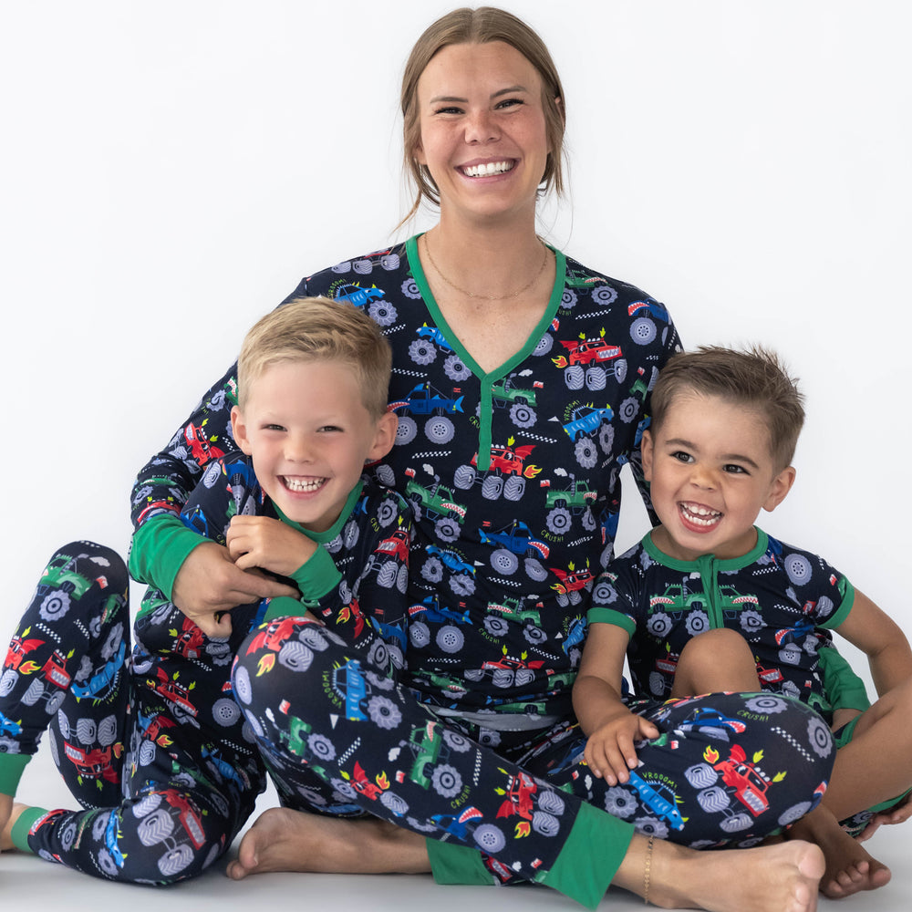 Mother and sons wearing the Monster Truck Madness print. Boy on the left is in the Monster Truck Madness Pajama Set and the mother in the middle is wearing the Monster Truck Madness Women's Pajama Top & Pants. Boy on the right is in the Monster Truck Madness Shorty Zippy