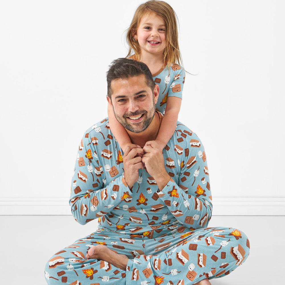 father and child wearing matching S'mores Galore pjs. Dad is wearing men's S'mores Galore pj top and matching men's pj pants, his child is wearing a matching two piece short sleeve pj set