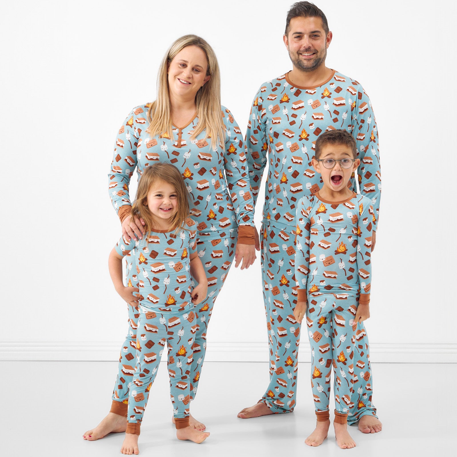 Family of four wearing matching S'mores Galore pjs in men's, women's, and children's two piece styles