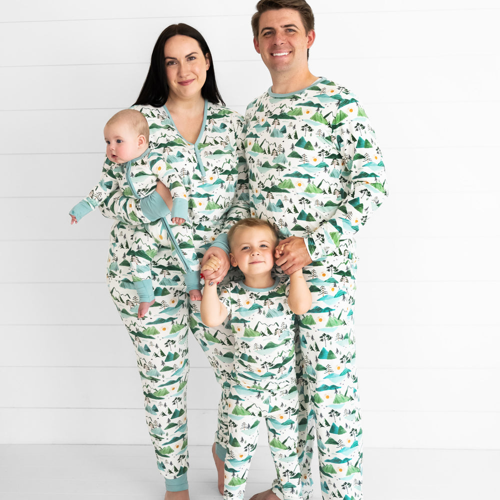 family of four wearing matching Mountain Mist printed pjs in women's, men's, and children's styles