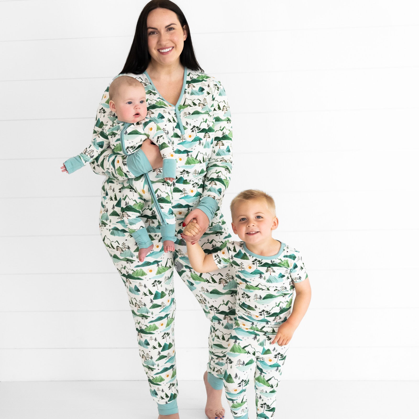 woman and her two children wearing matching Mountain Mist women's pj pants and matching womens top. Her children are wearing two piece and zippy styles