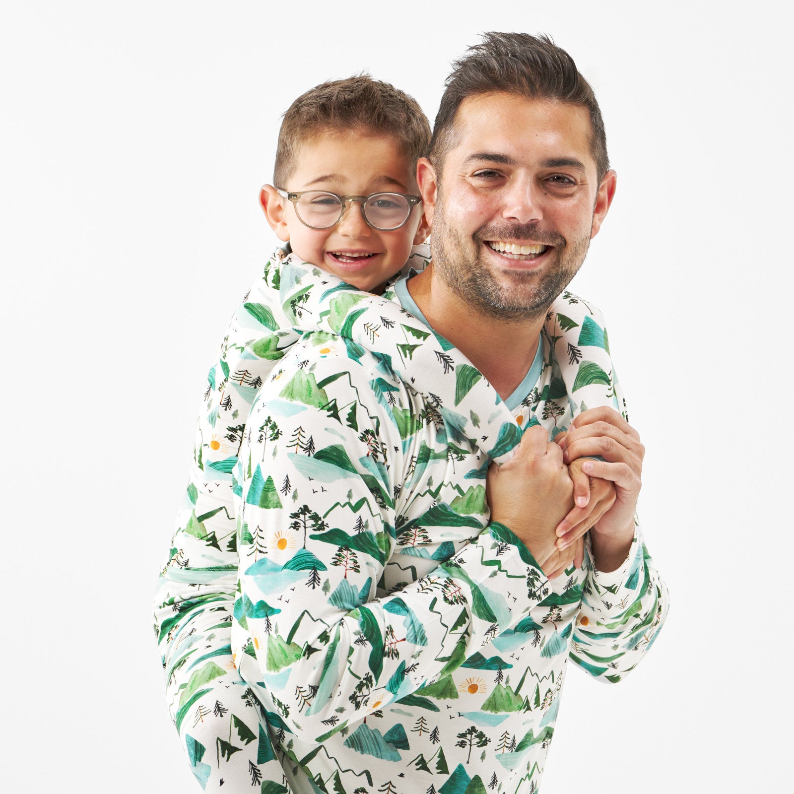 close up image of a father and son wearing matching Mountain Mist pjs in men's and children's two piece styles