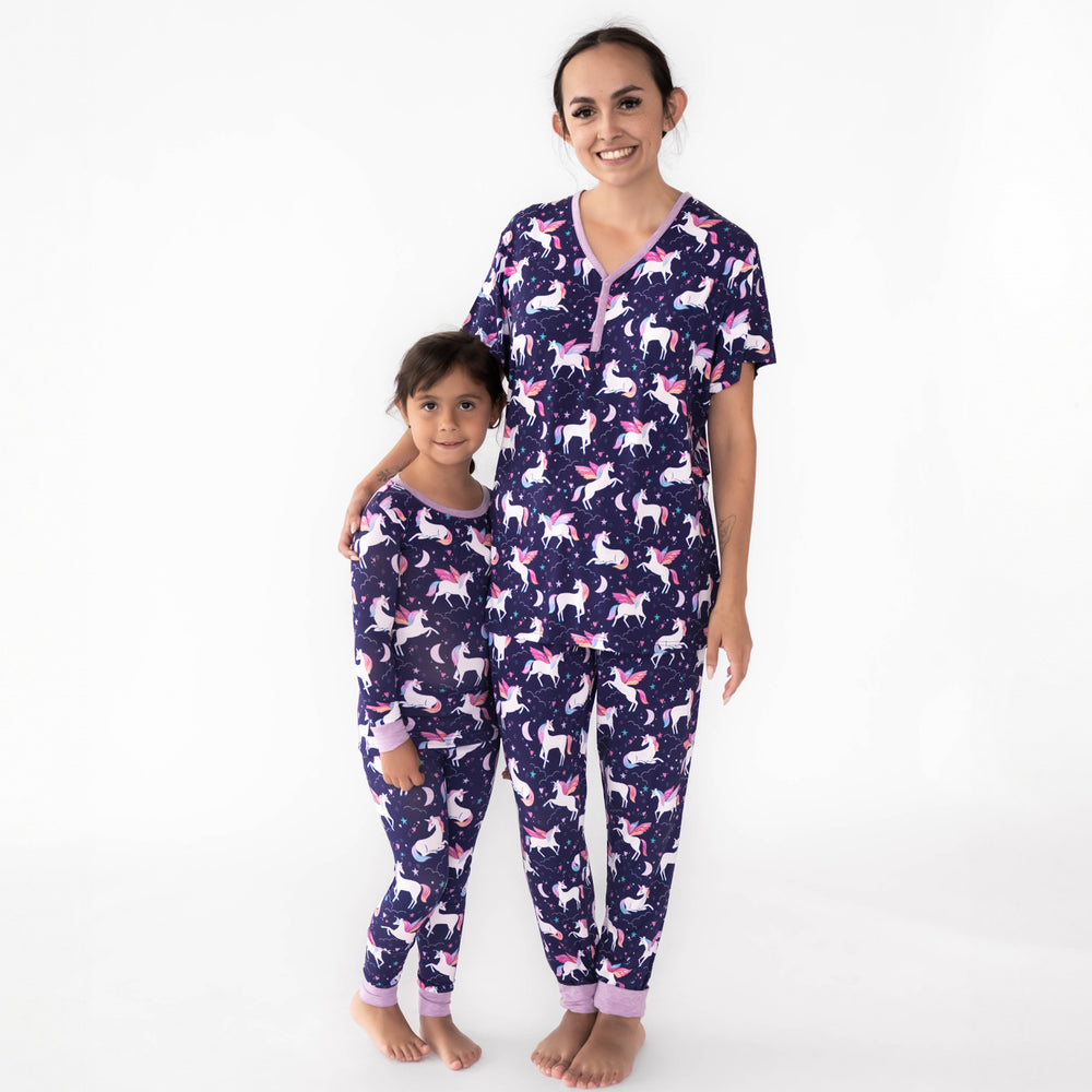 Mother and daughter wearing the Magical Skies print. Girl on the left is wearing the Magical Skies Two-Piece Pajama Set and the mother is wearing the Women's Short Sleeve PJ Top & Pants 