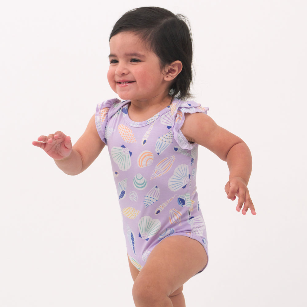 Child playing wearing a Sandy Treasures flutter bodysuit