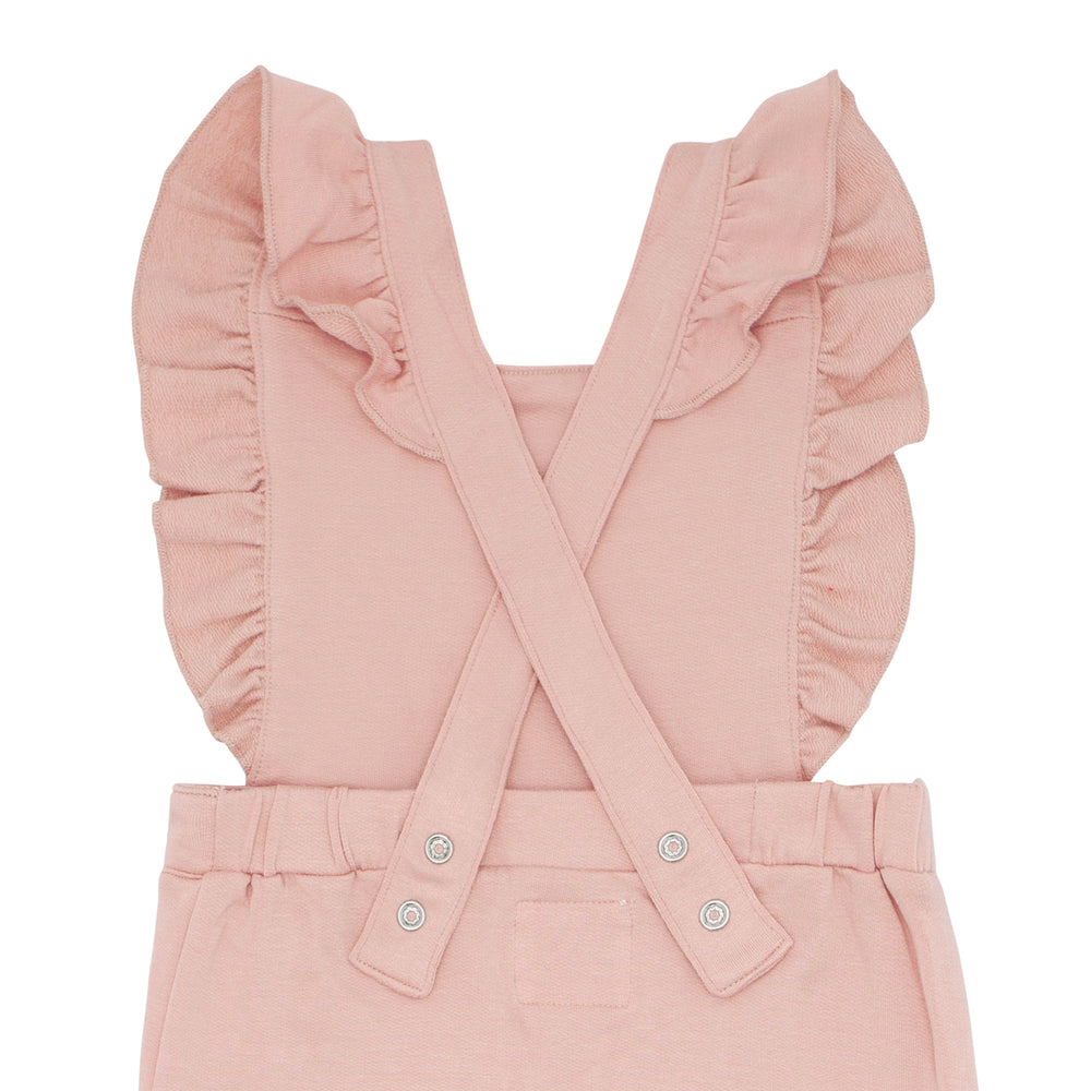 Close up flat lay image of a Mauve Blush ruffle overall