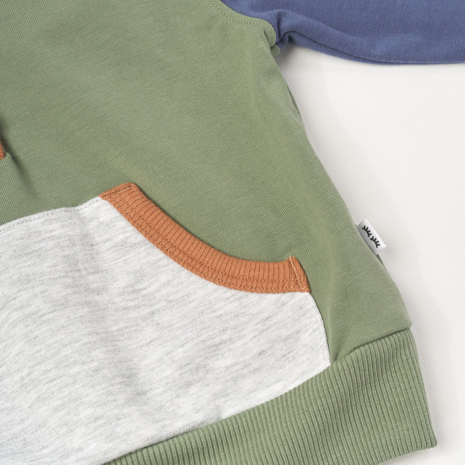 Close up flat lay image of Moss Colorblock Henley Hoodie detailing the front pocket