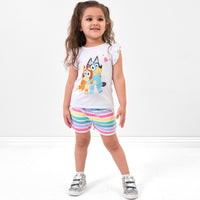 Girl posing while wearing the Bluey & Bingo Graphic Flutter Tee