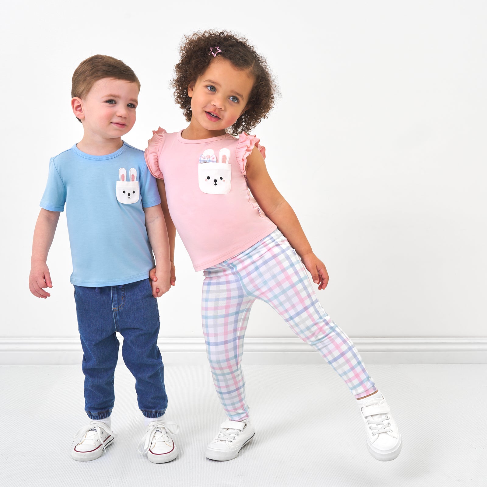 Two children wearing coordinating Easter Play outfits by Little Sleepies
