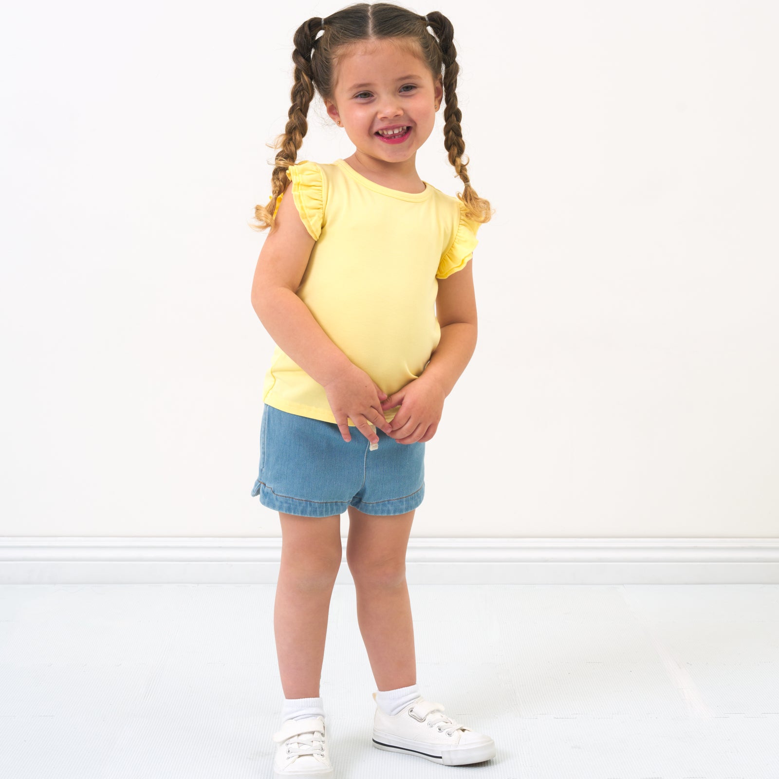 Child wearing a Lemon Twist Flutter Tee paired with Light Denim shorts