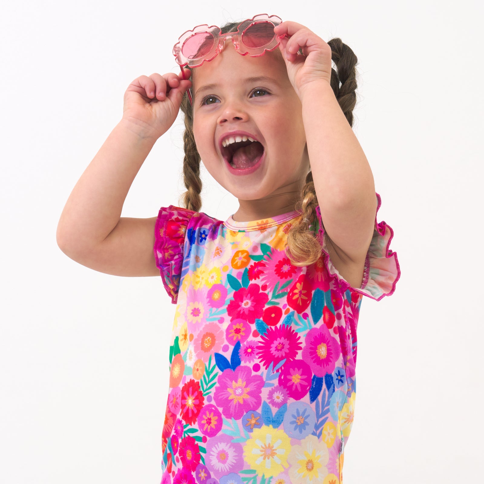 Close up image of a child wearing a Rainbow Blooms flutter tee