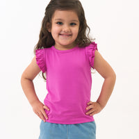 child posing wearing a Rouge Pink Flutter Tee paired with Light Denim shorts