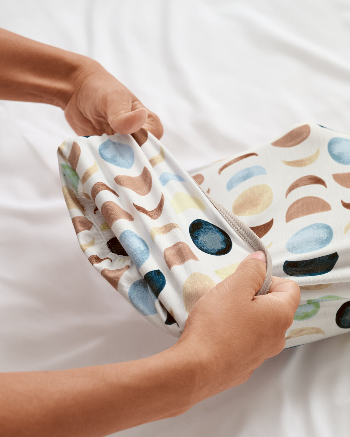 Adult demonstrating the envelop sweep on the Luna Neutral Infant Gown