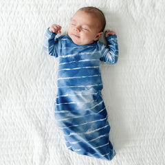 Infant laying on a blanket wearing a Blue Tie Dye Dreams infant gown