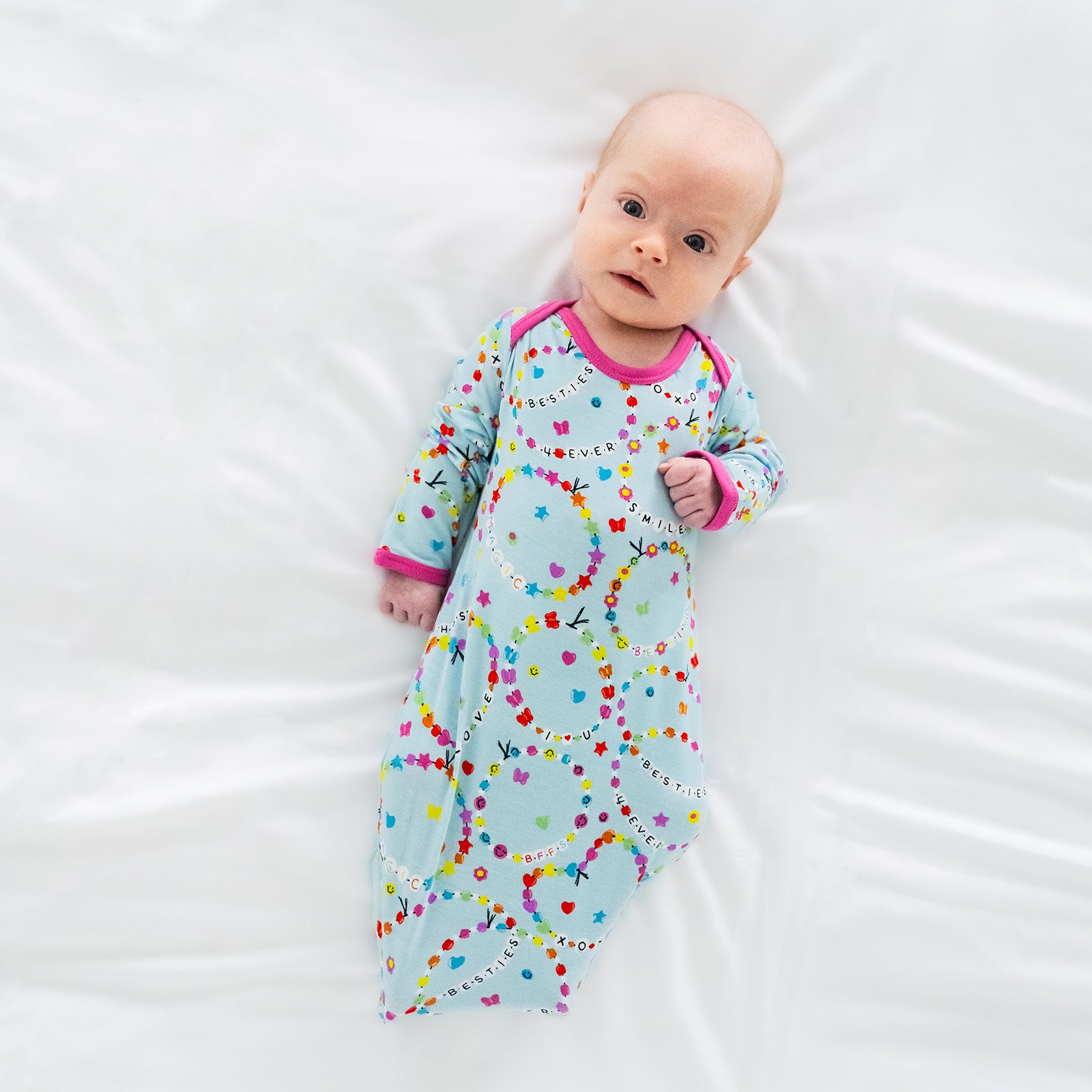 Image of a child laying on a bed wearing a Friends Forever Infant Gown
