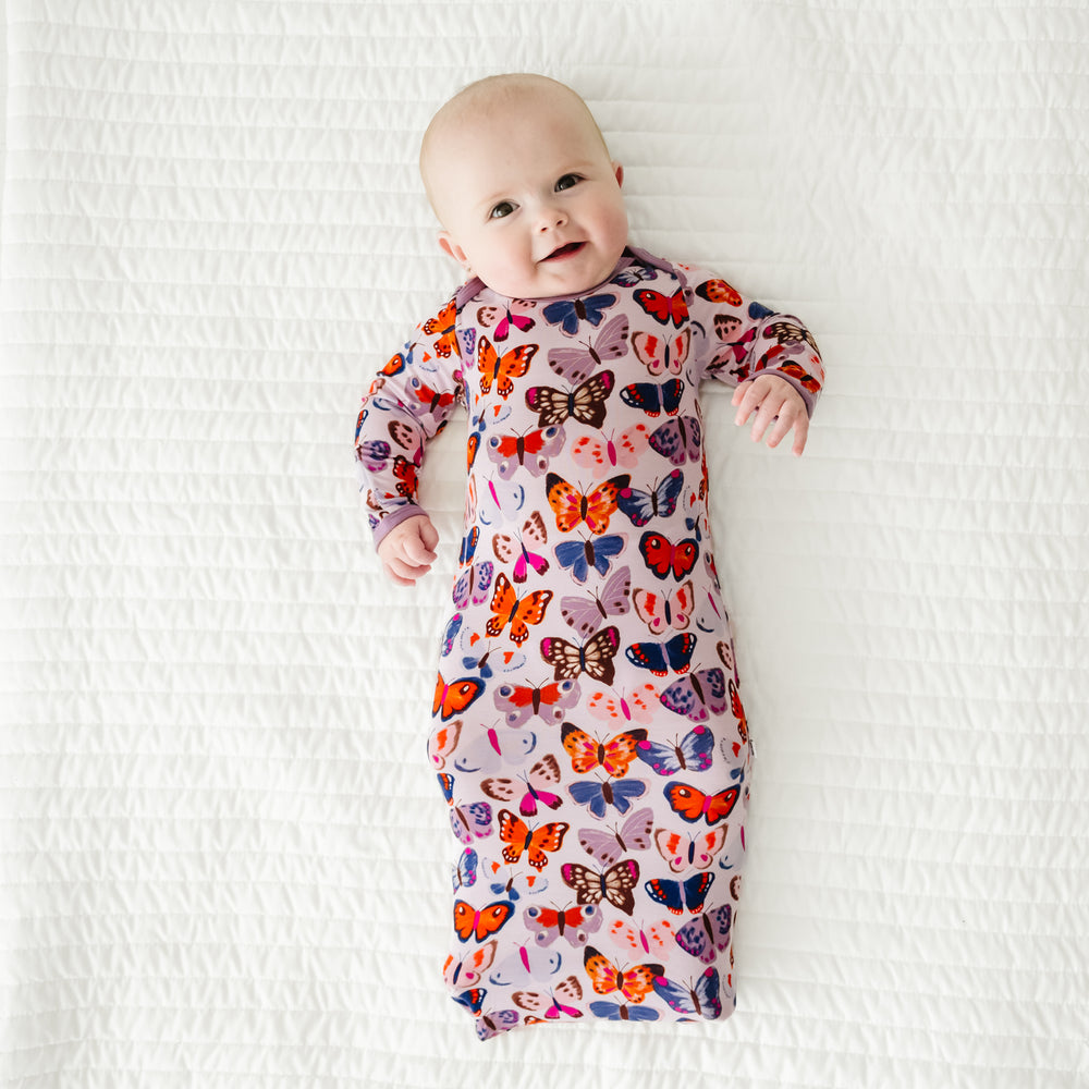 Child laying on a blanket wearing a Butterfly Kisses infant gown