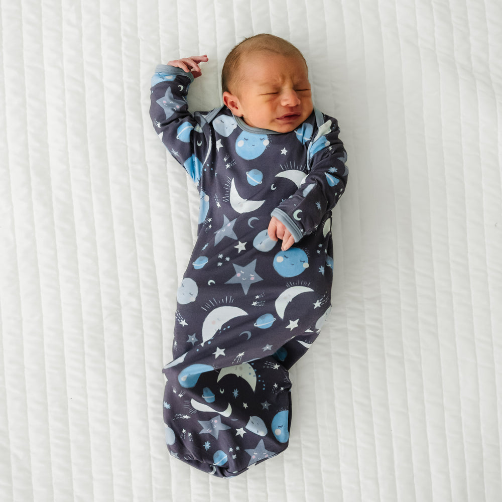 Child laying on a bed wearing a Blue To the Moon and Back Infant Gown