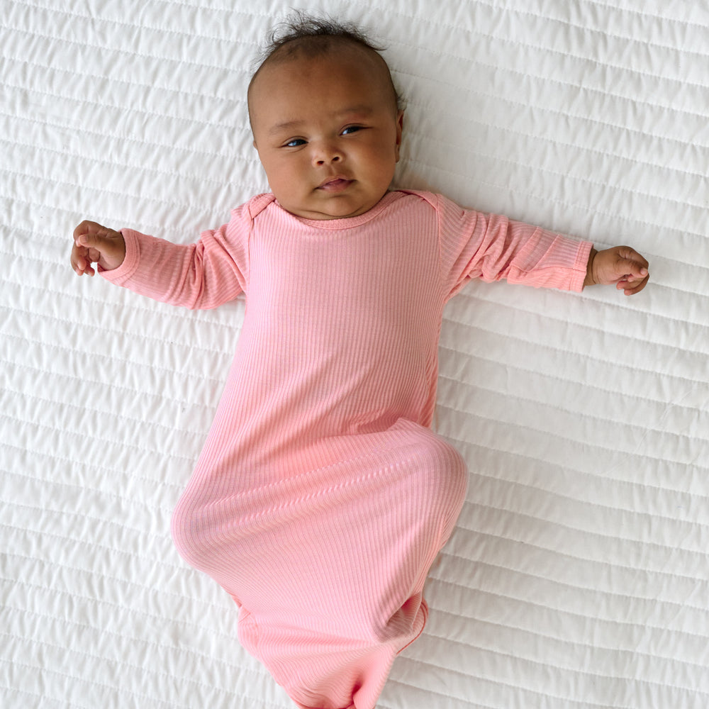 Alternative top image of baby laying down while in a Bubblegum Ribbed Infant Gown