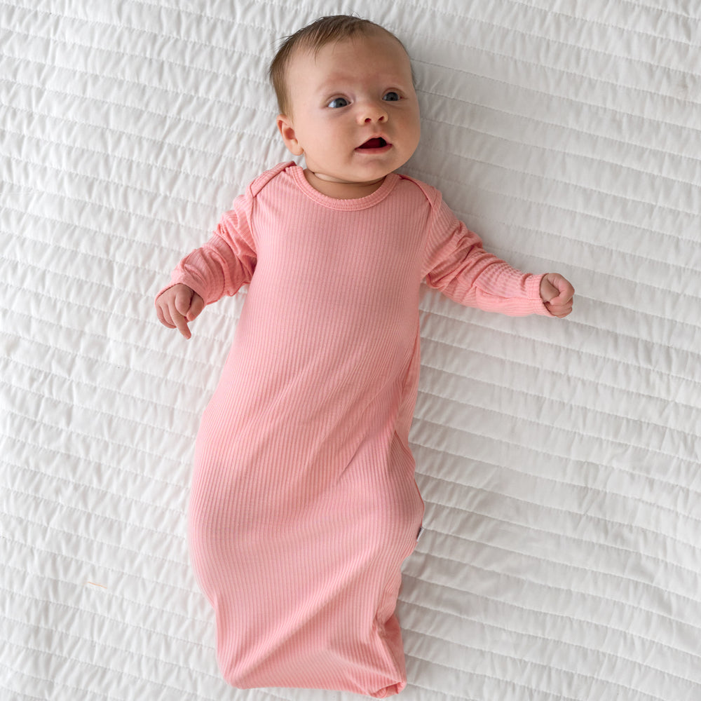 Top view image of baby laying in the Bubblegum Ribbed Infant Gown