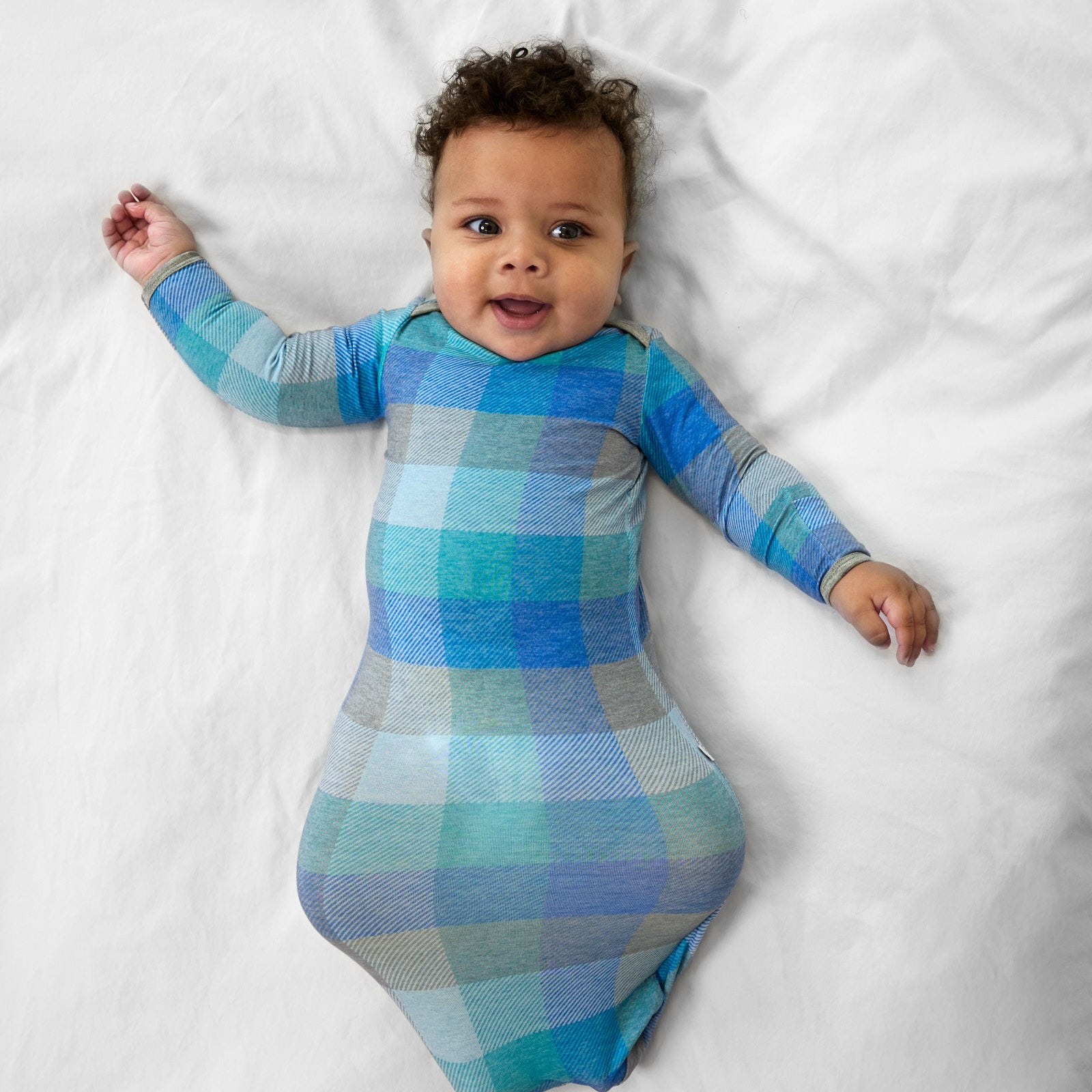 additional alternate image of a child laying on a bed wearing an Arctic Plaid infant gown
