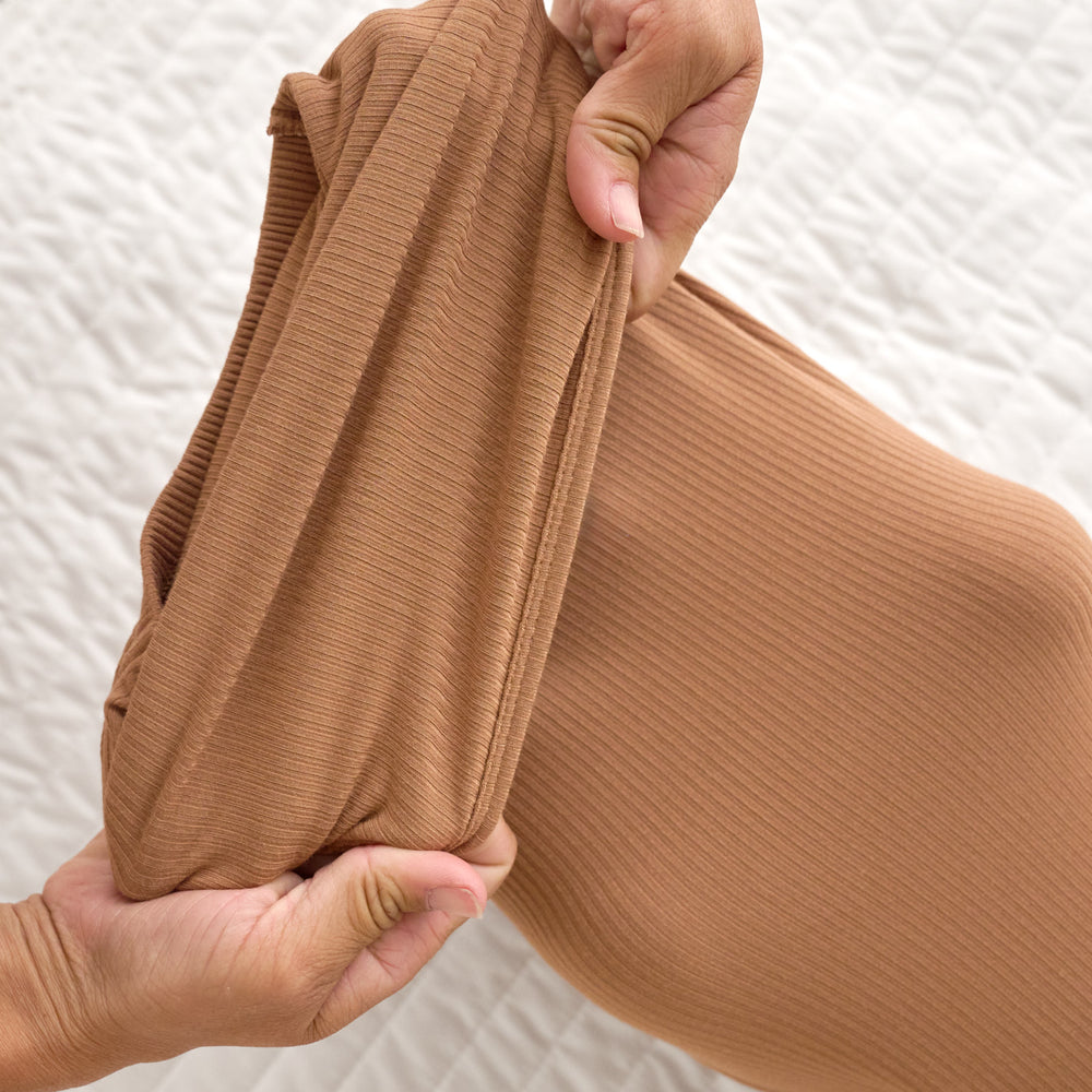 Close image of the fold over bottom detail on the Caramel Ribbed Infant Gown