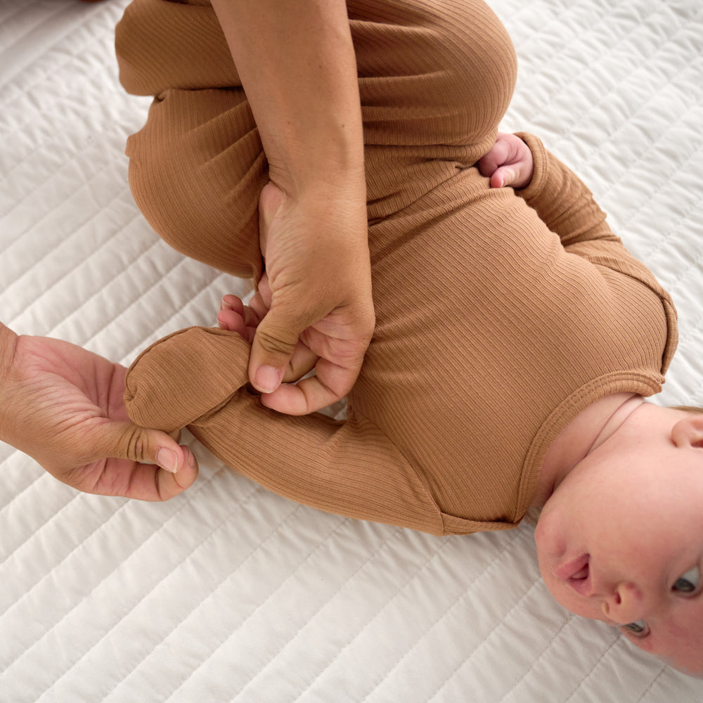 Close up image of the fold over hand details applied on the Caramel Ribbed Infant Gown