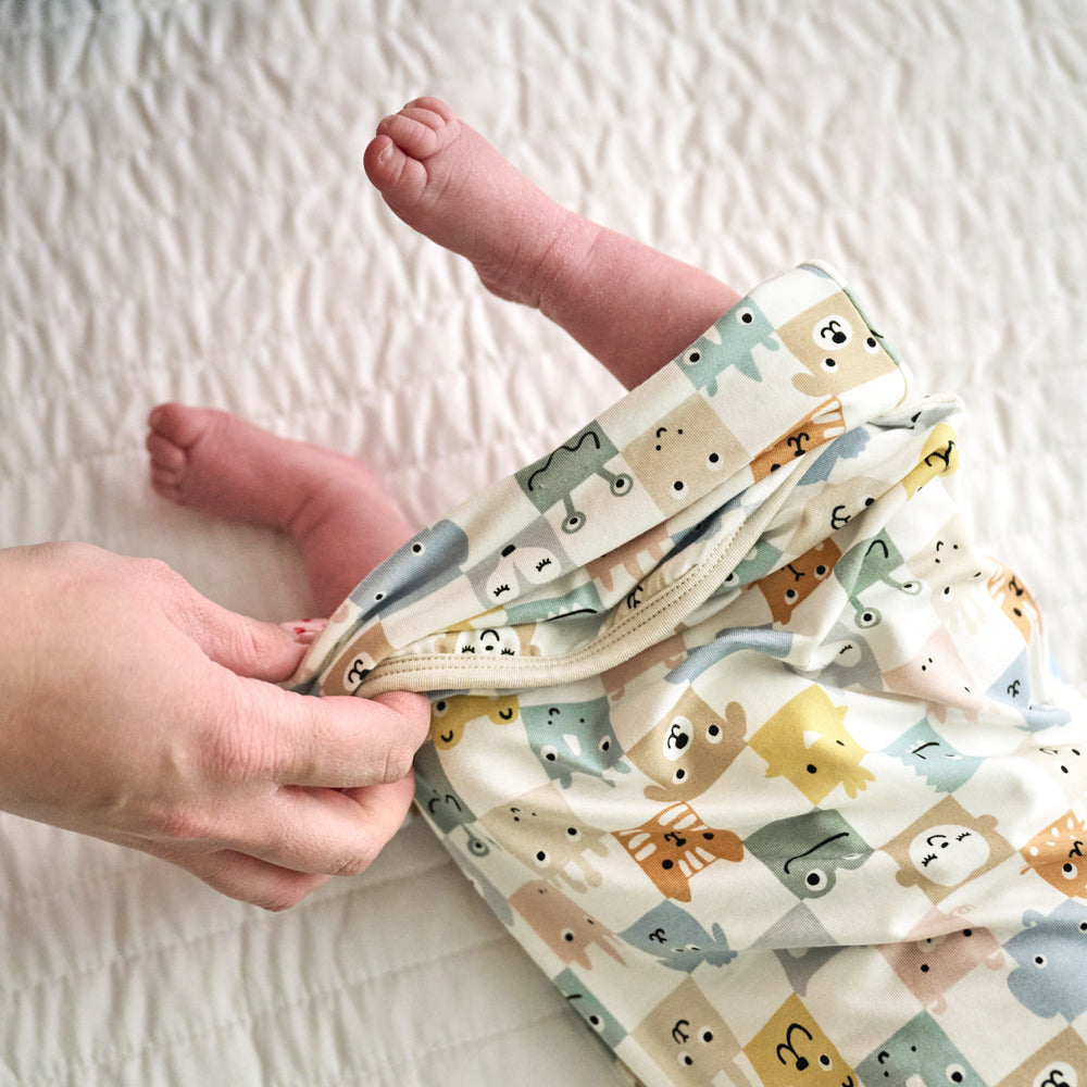 Close up image of a parent putting a Check Mates Infant Gown on an infant, detailing the envelope bottom